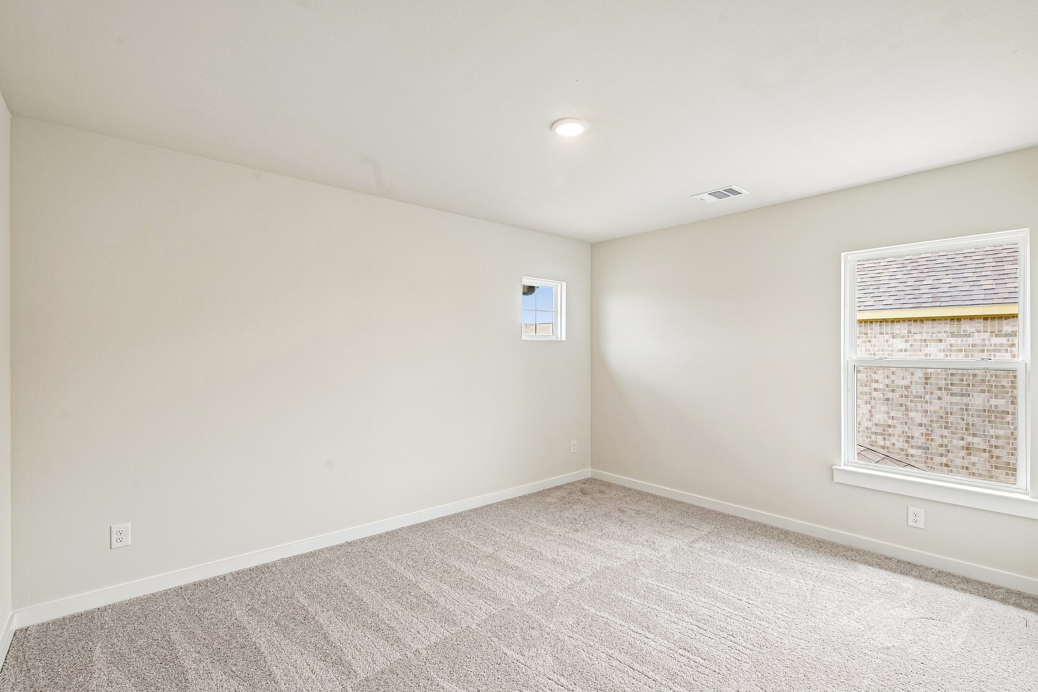 A room with a window and a carpet.