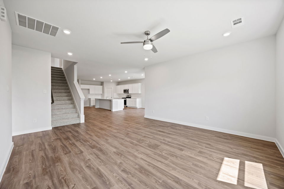 A room with a wood floor and a ceiling fan.