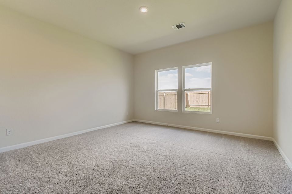A room with a carpet and windows.