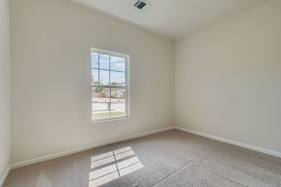 A room with a window and a rug.