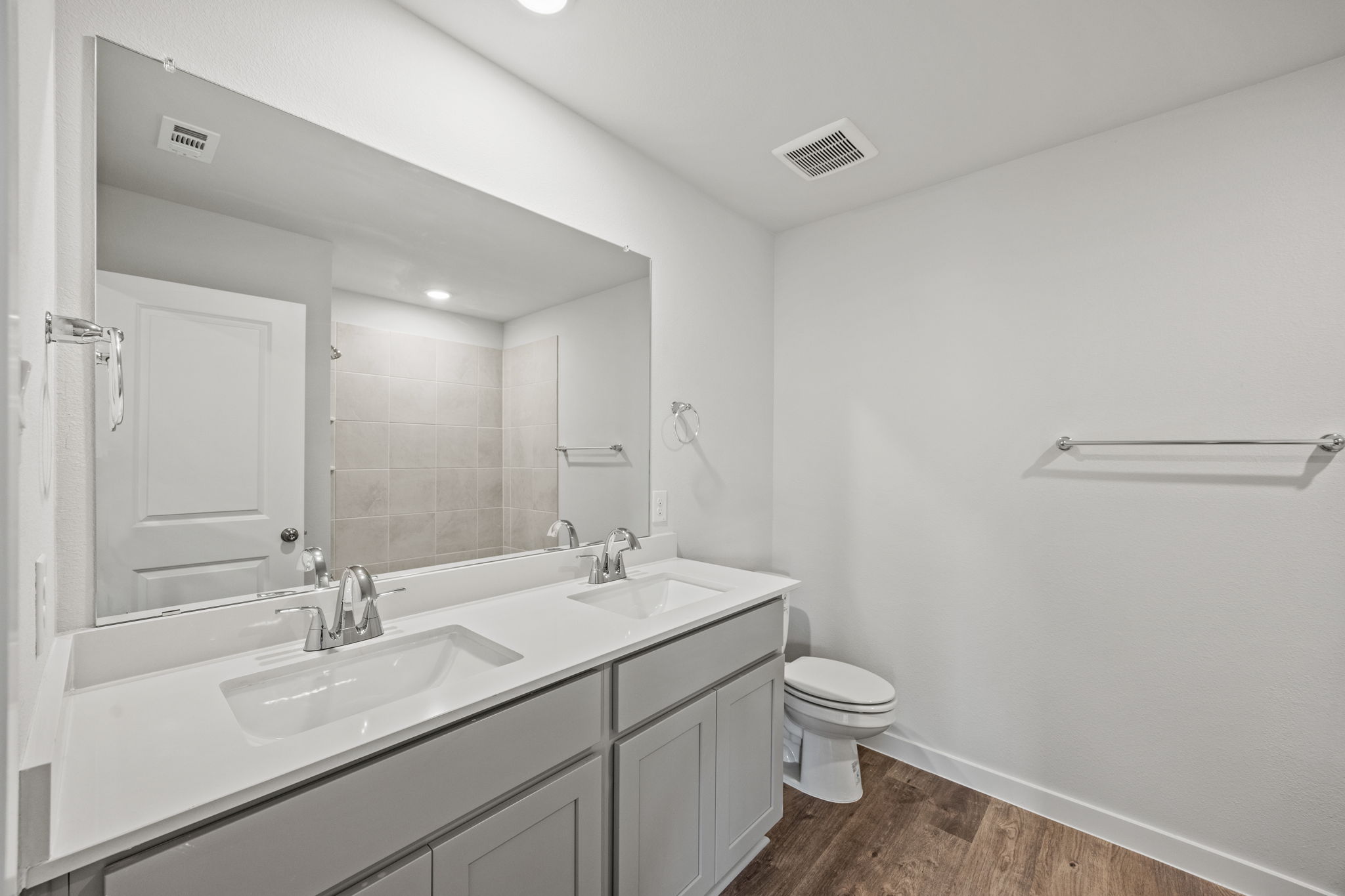 A bathroom with a sink toilet and mirror.