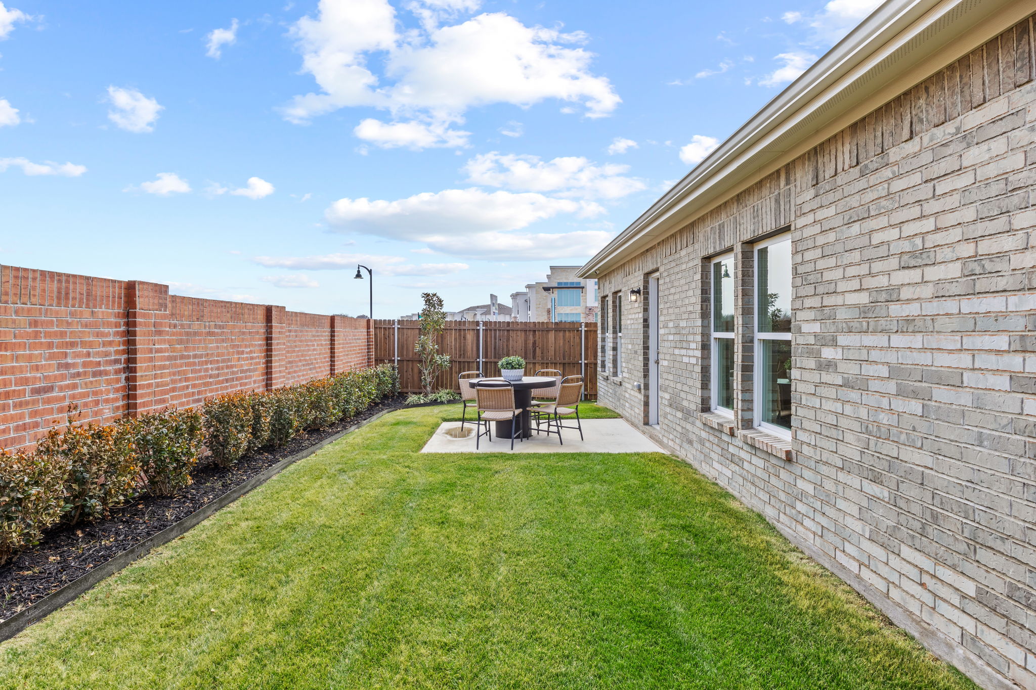 A brick building with a table and chairs in the front.