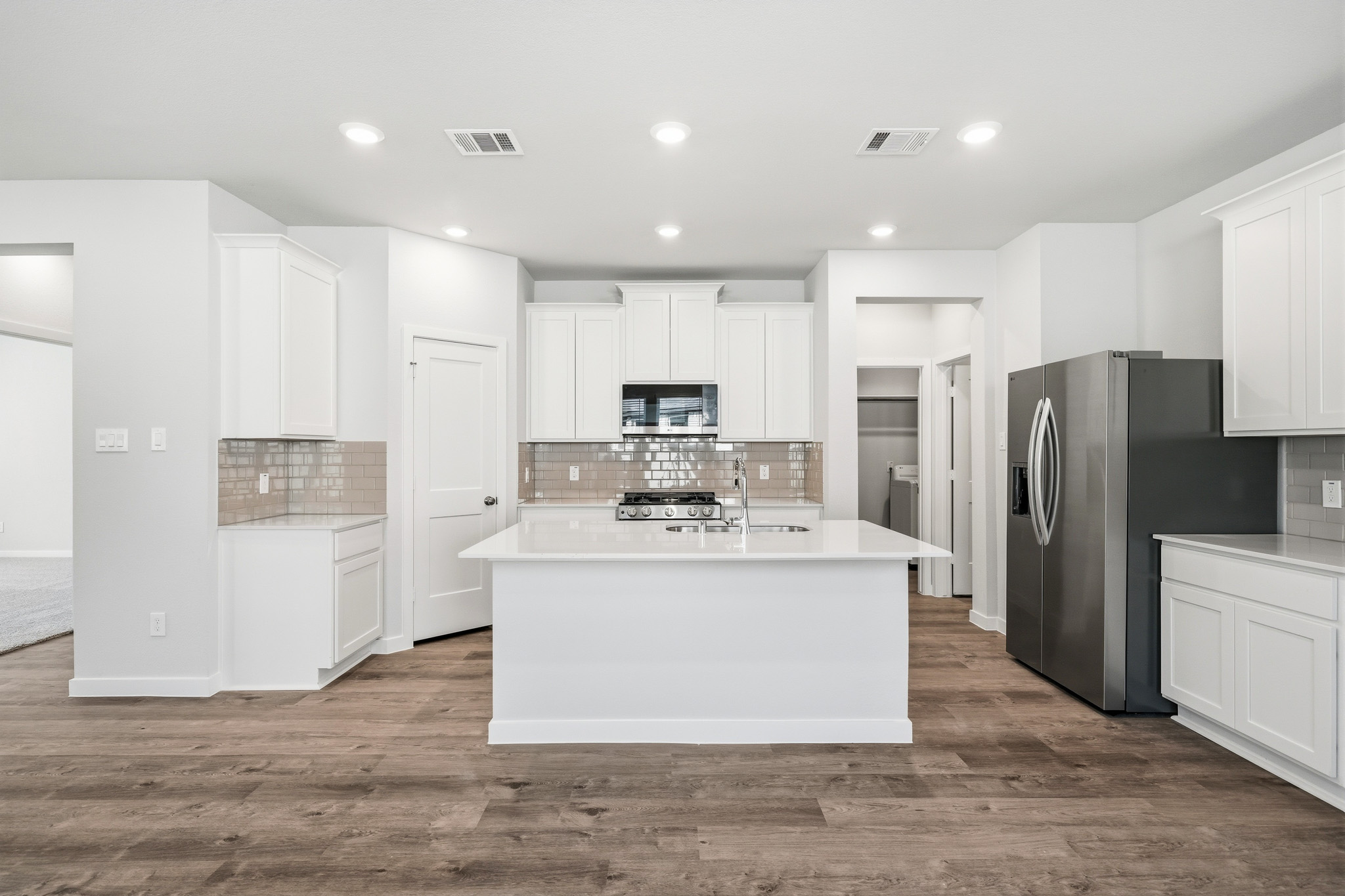 A kitchen with white cabinets.