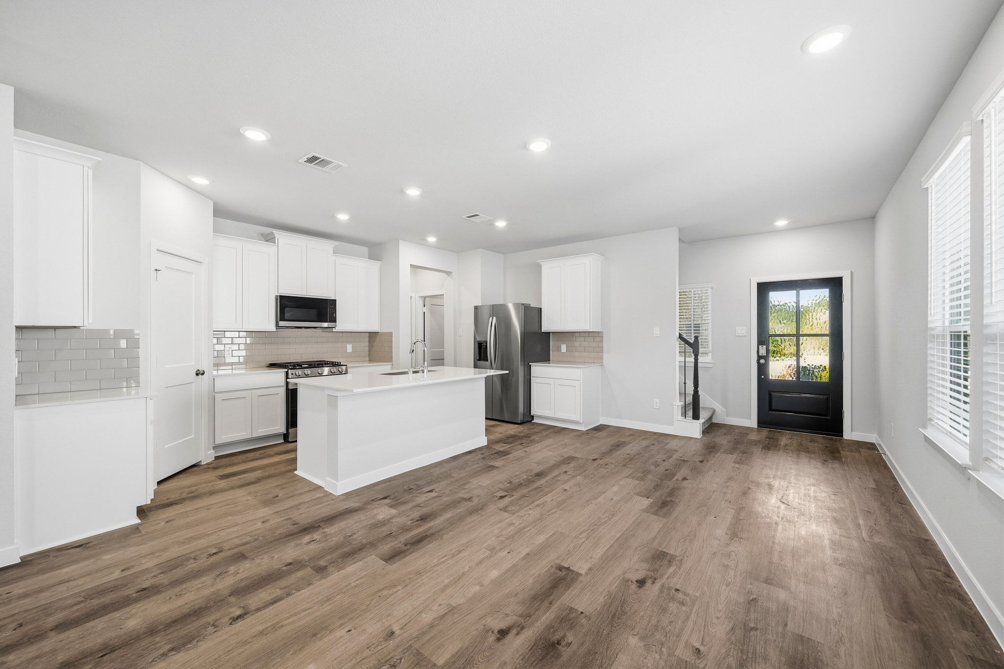 A kitchen with white cabinets.