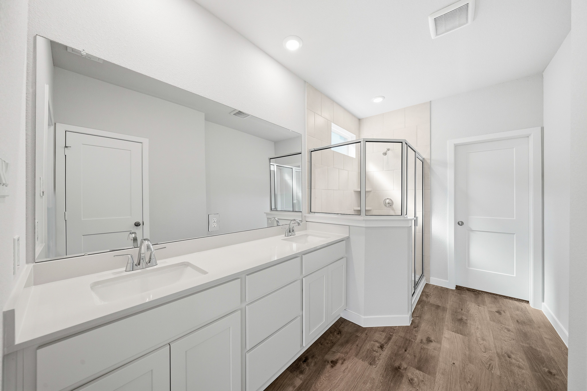 A bathroom with white cabinets.