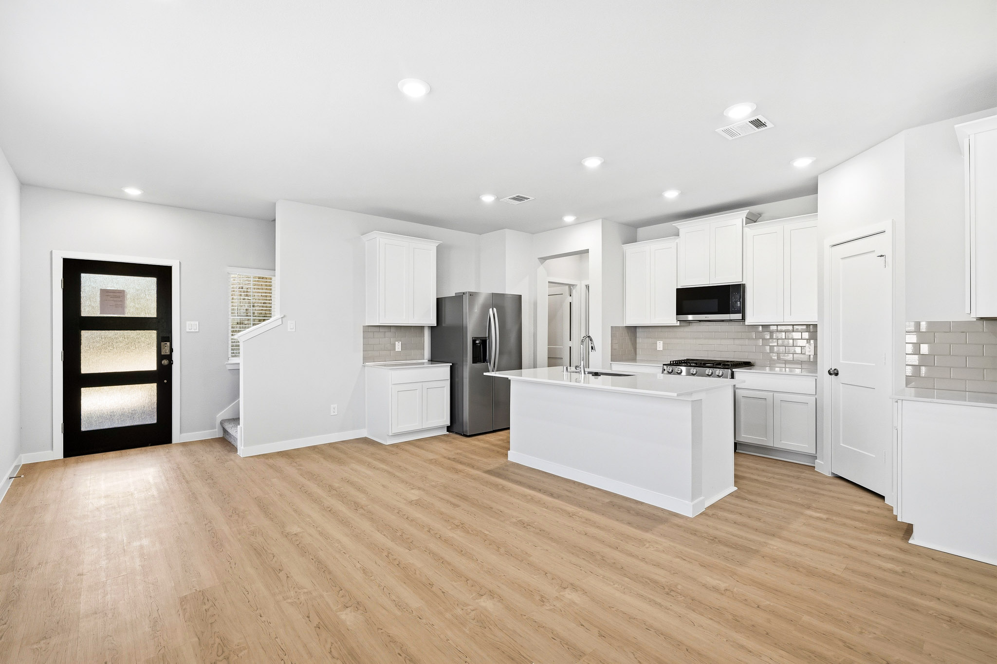 A kitchen with white cabinets.