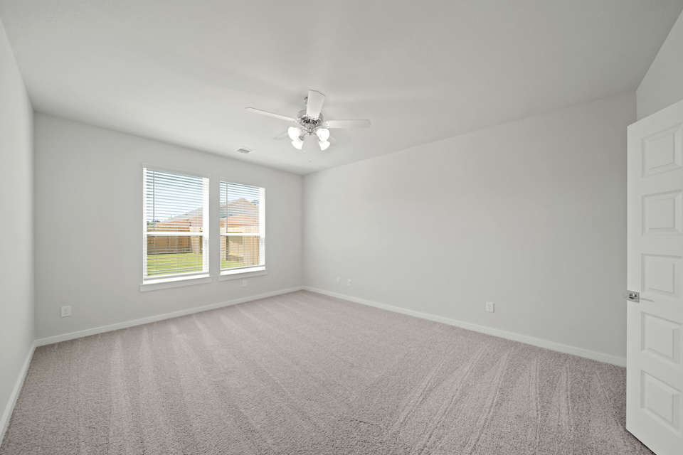 A room with a ceiling fan and a window.