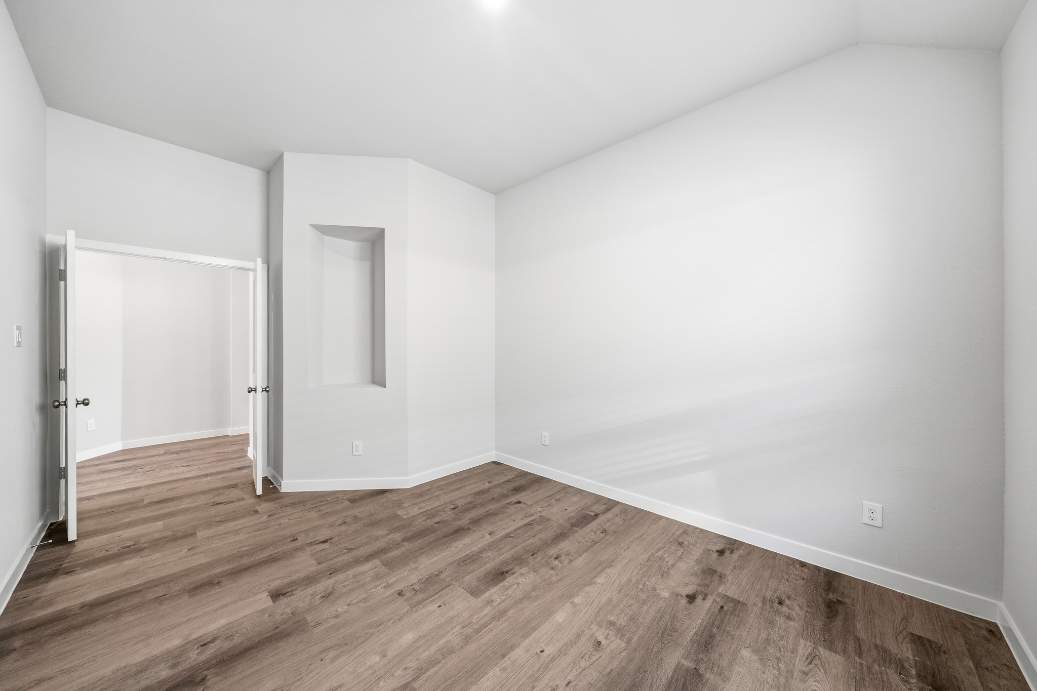 A room with a wood floor and white walls.