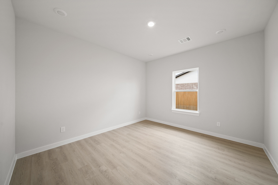A room with a wood floor and a window.
