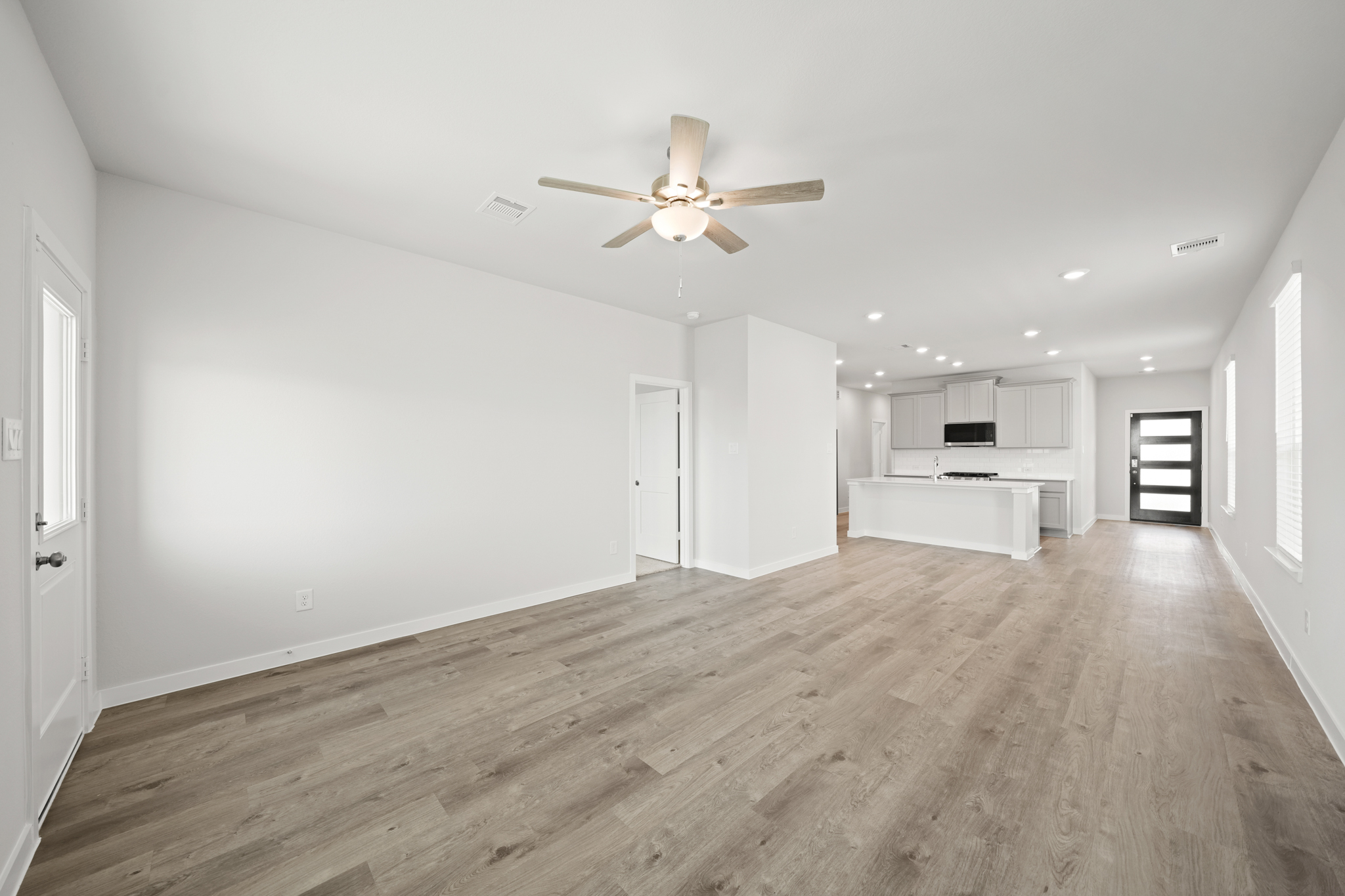 A room with a wood floor and a ceiling fan.