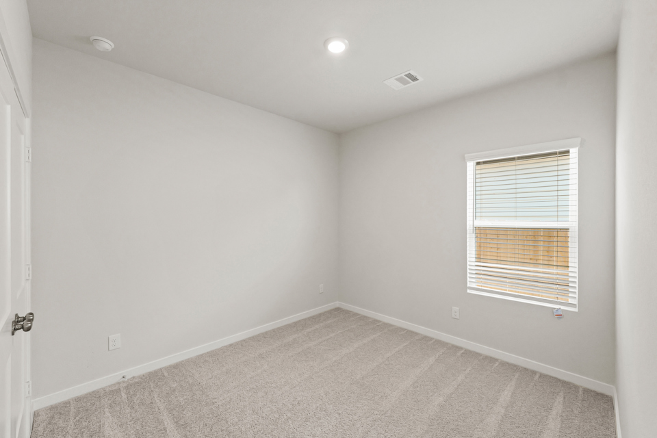A room with a window and a carpet.