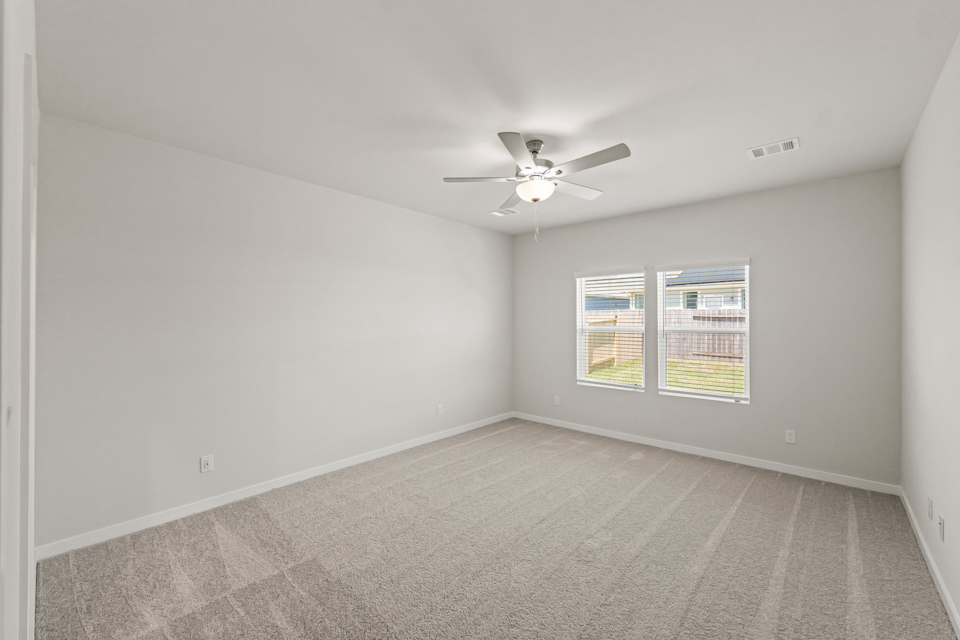 A room with a ceiling fan and a window.