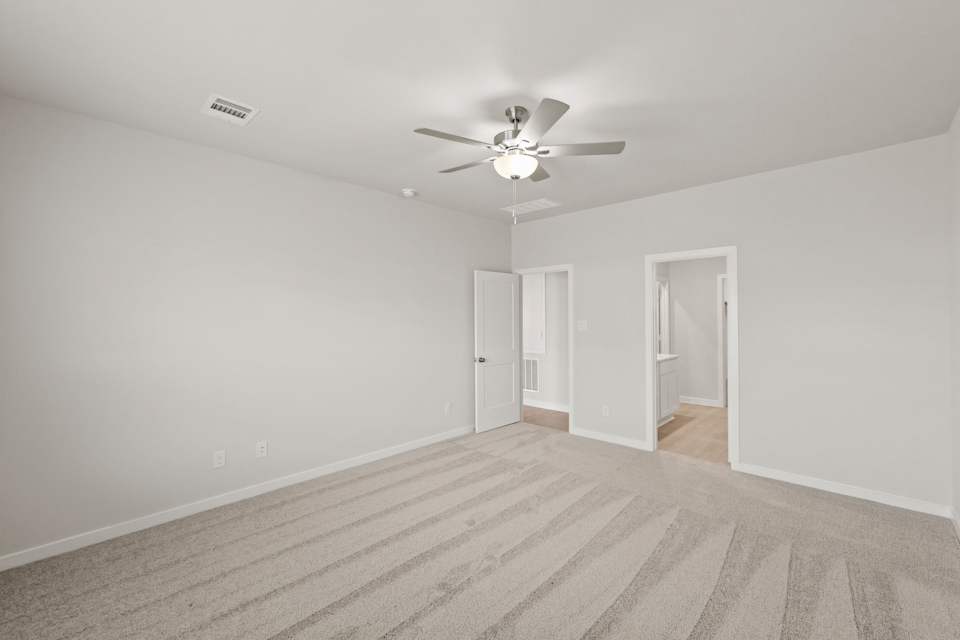 A room with a ceiling fan and a wood floor.