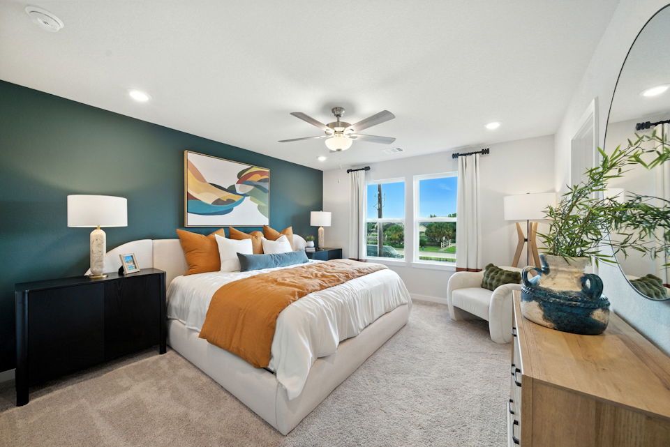 A bedroom with a bed and a fan.