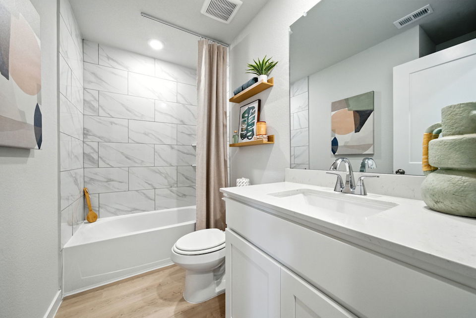 A bathroom with a tub sink and toilet.