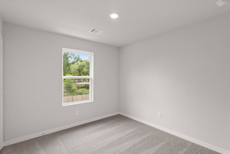 A room with a window and a carpet.