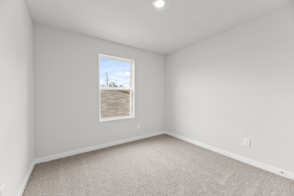 A room with a window and a carpet.