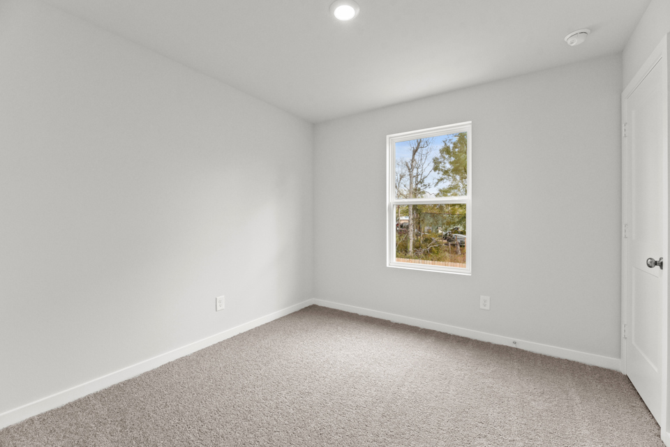 A room with a window and a carpet.