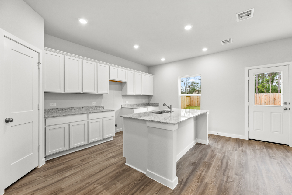 A kitchen with white cabinets.