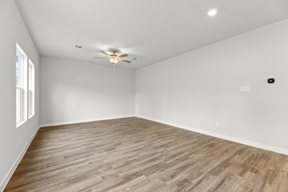 A room with a wood floor and a ceiling fan.