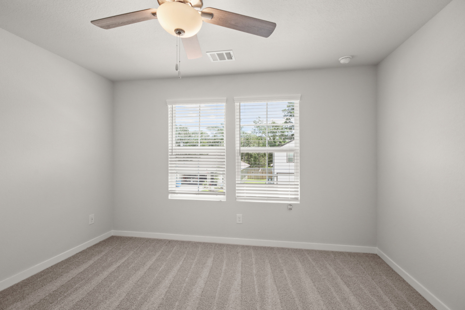 A room with a ceiling fan and a window.