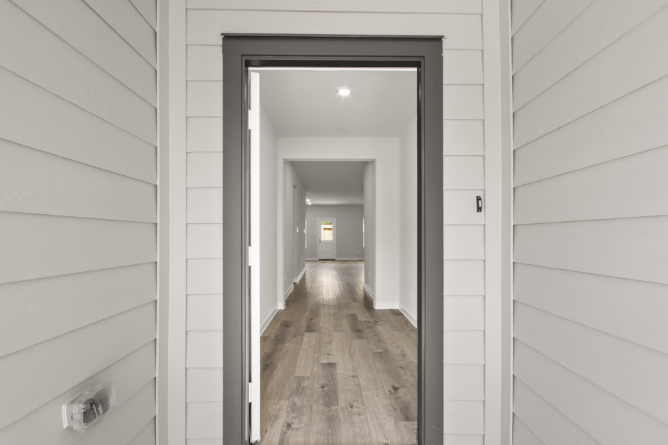 A hallway with a wood floor.