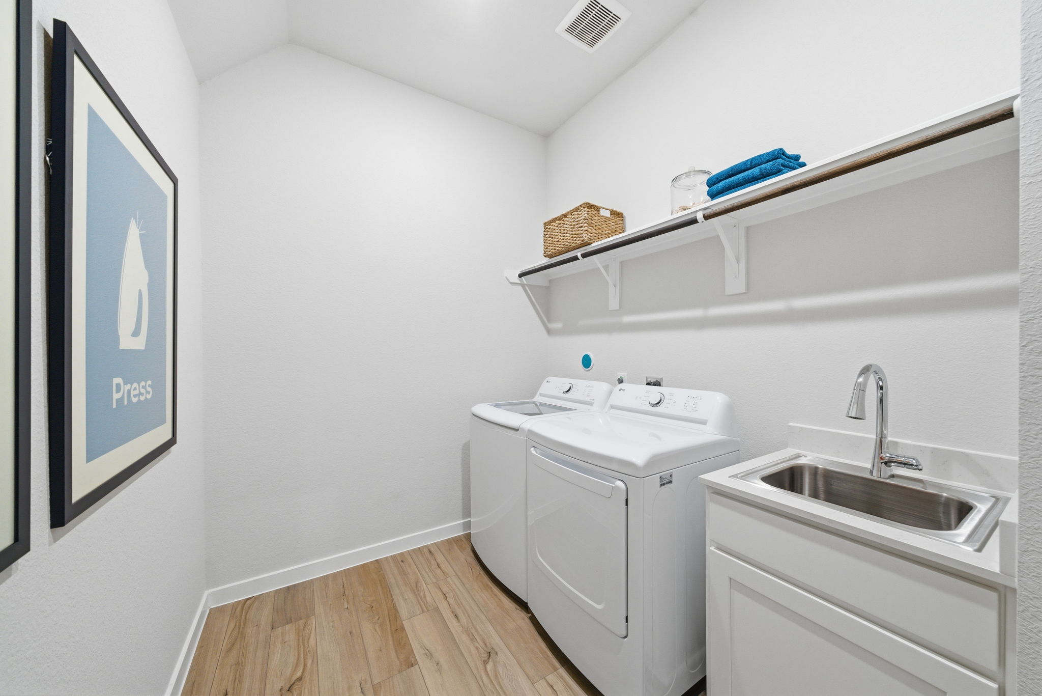 A white kitchen with a sink and shelves.