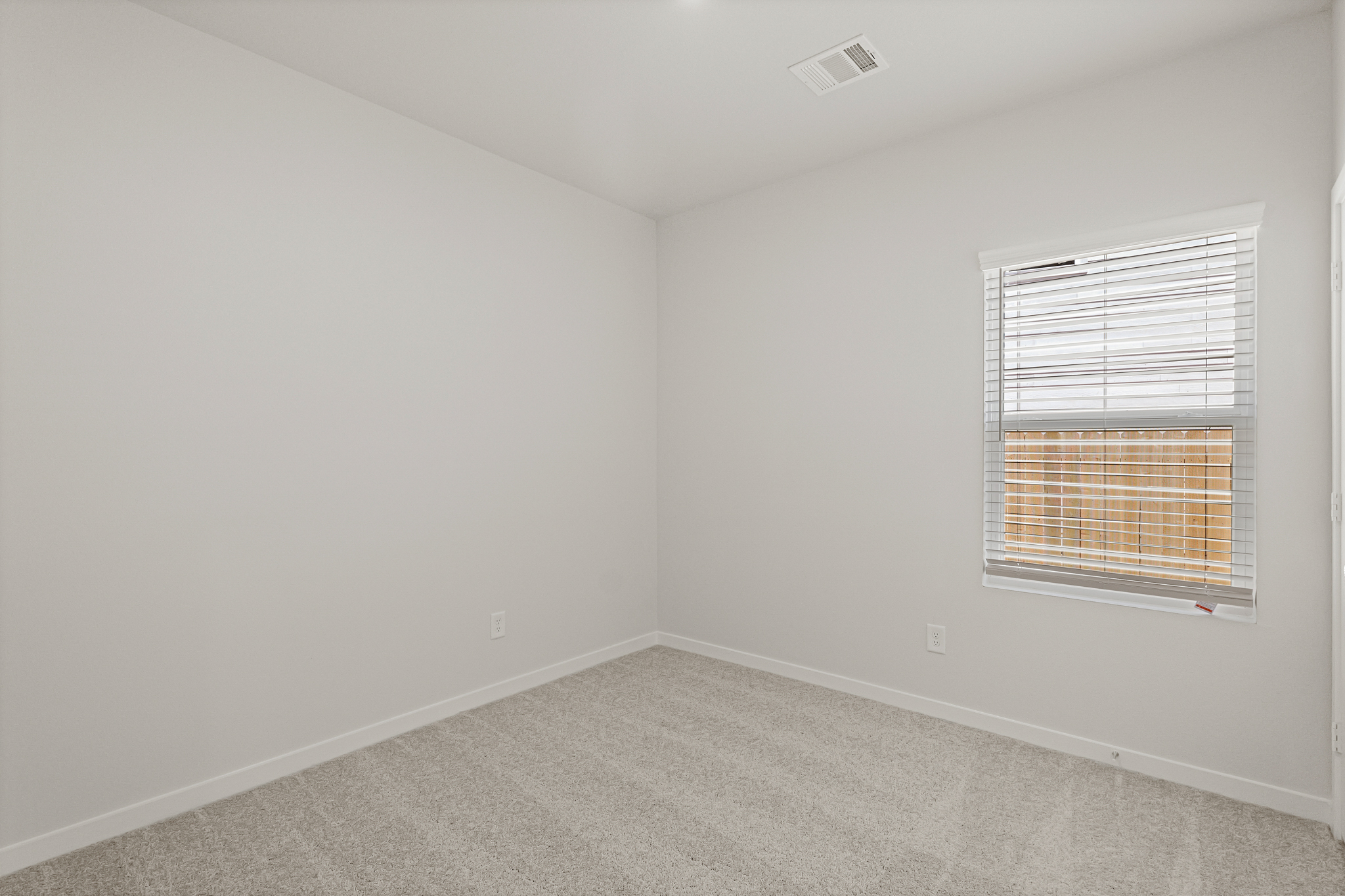 A room with a window and a carpet.