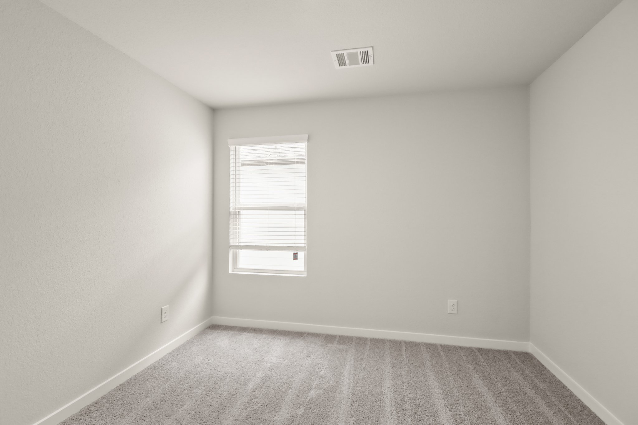 A room with a window and a carpet.