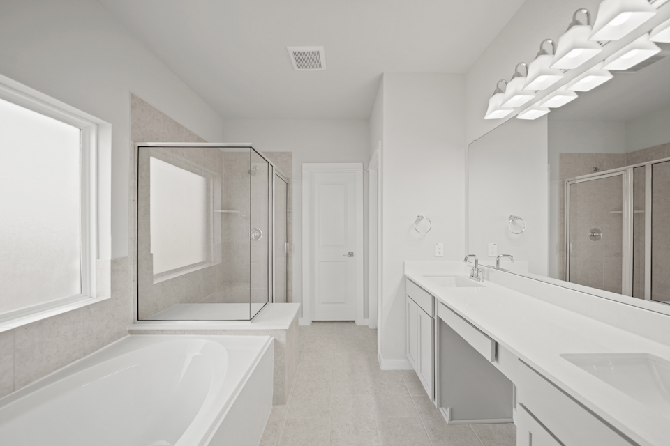 A bathroom with a tub sink and mirror.