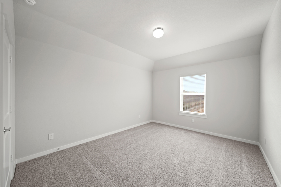 A room with a carpet and a window.