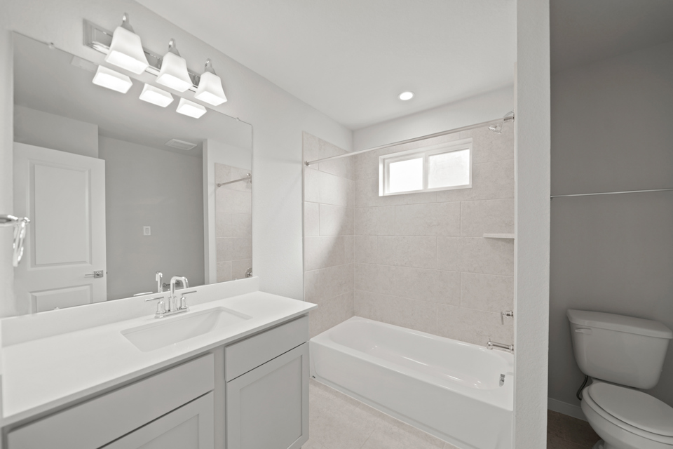 A bathroom with a tub sink and toilet.