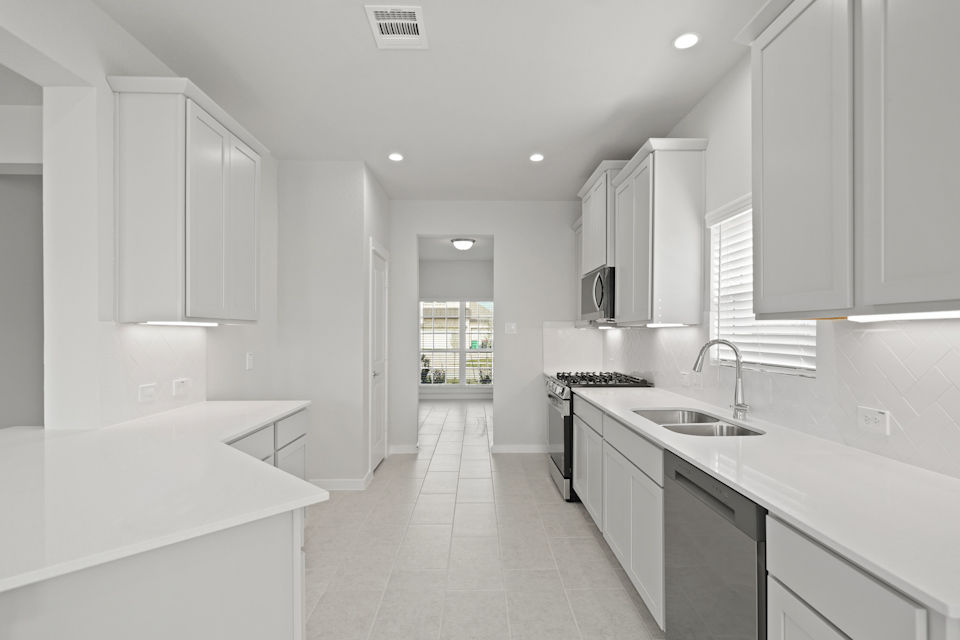 A kitchen with white cabinets.