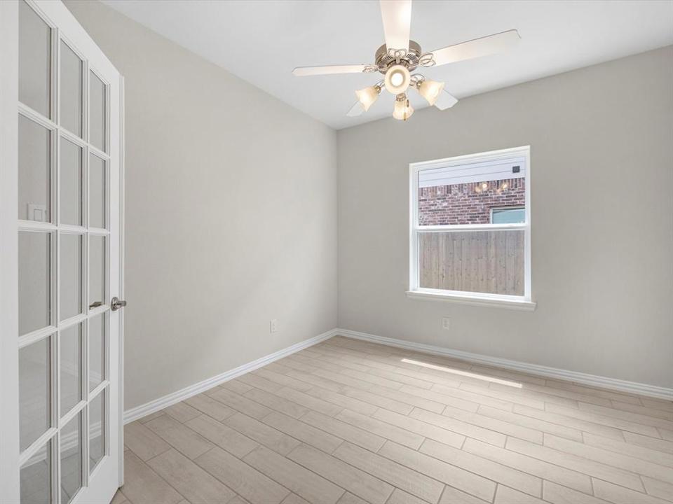 A room with a ceiling fan and a tile floor.