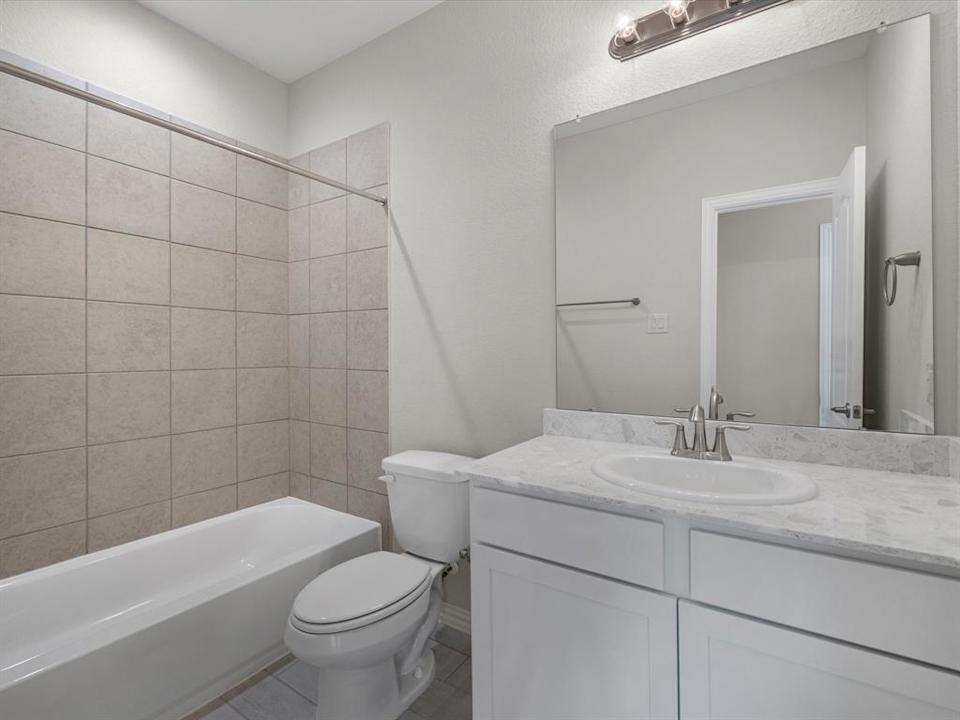 A bathroom with a tub sink and toilet.