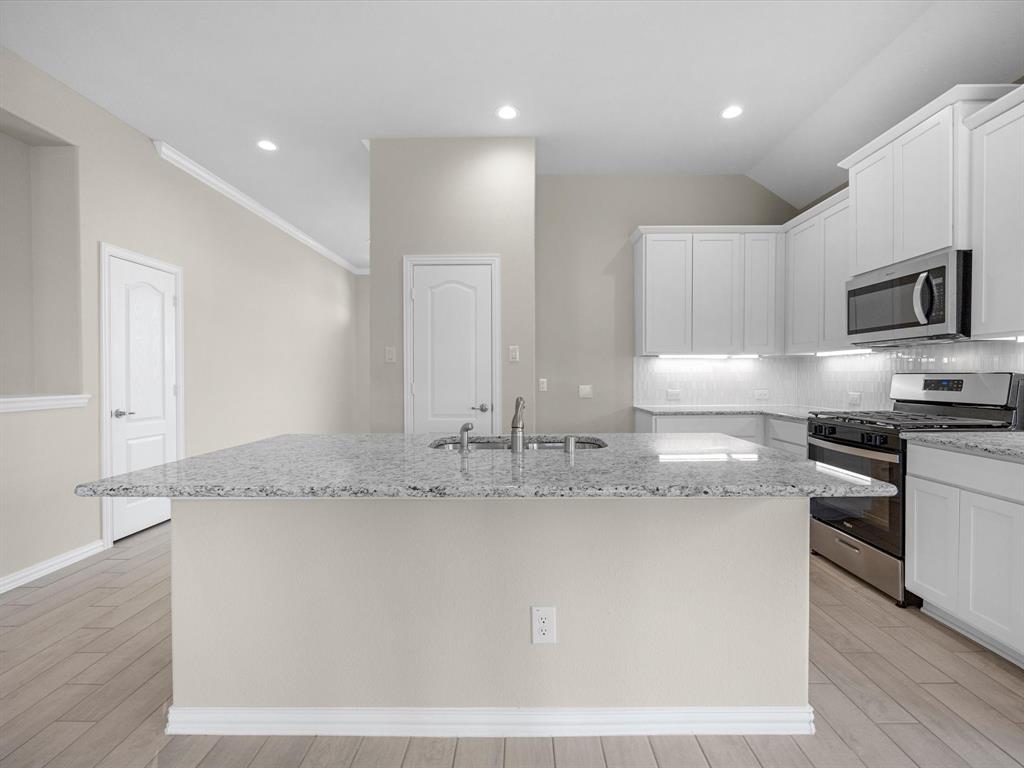 A kitchen with white cabinets.