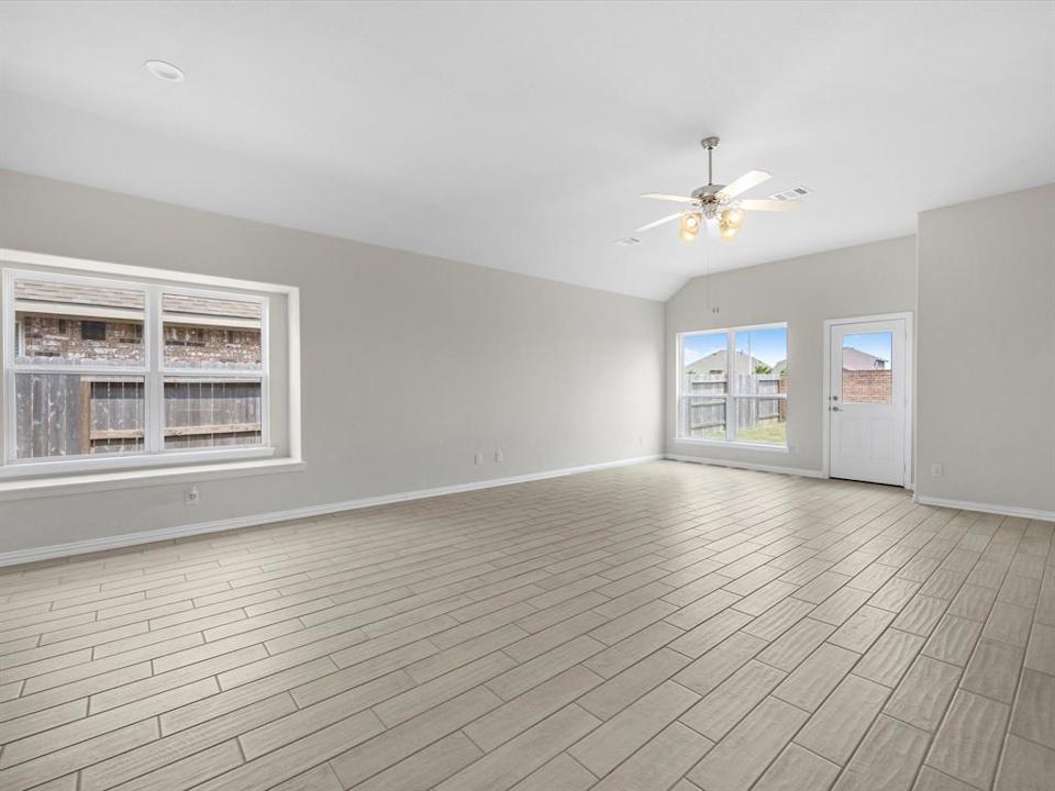 A room with a wood floor and a ceiling fan.