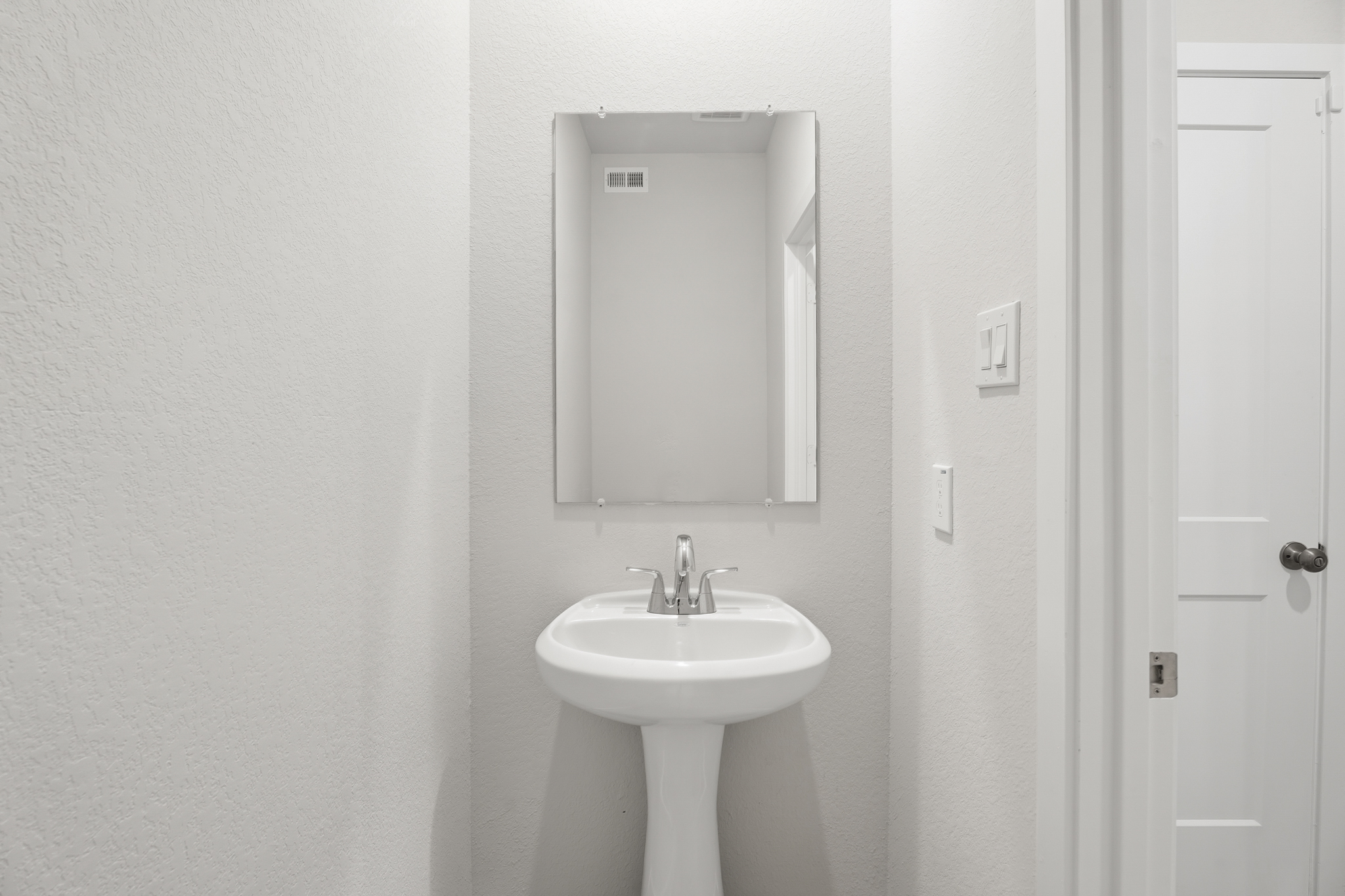A bathroom with a sink and mirror.