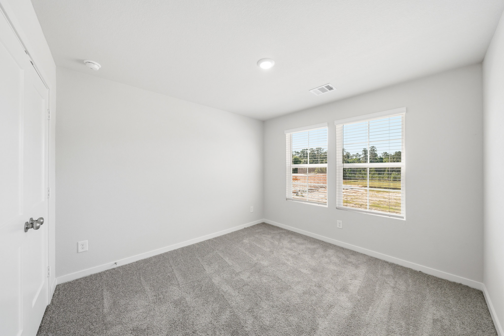 A room with a carpet and windows.