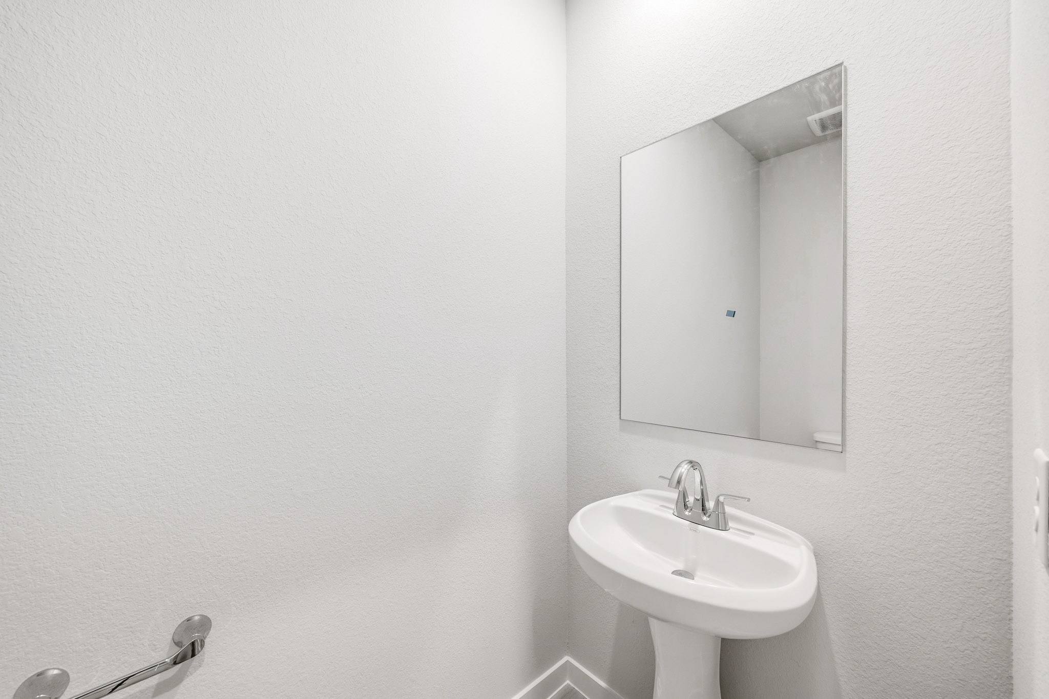 A bathroom with a mirror and sink.
