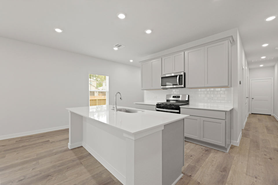 A kitchen with white cabinets.