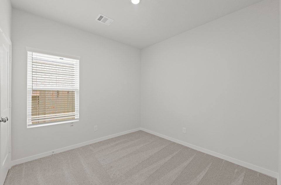 A room with a window and a carpet.