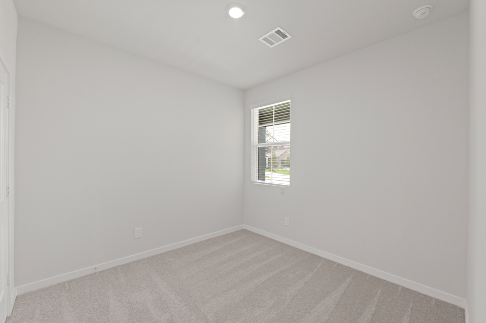 A room with a window and a carpet.