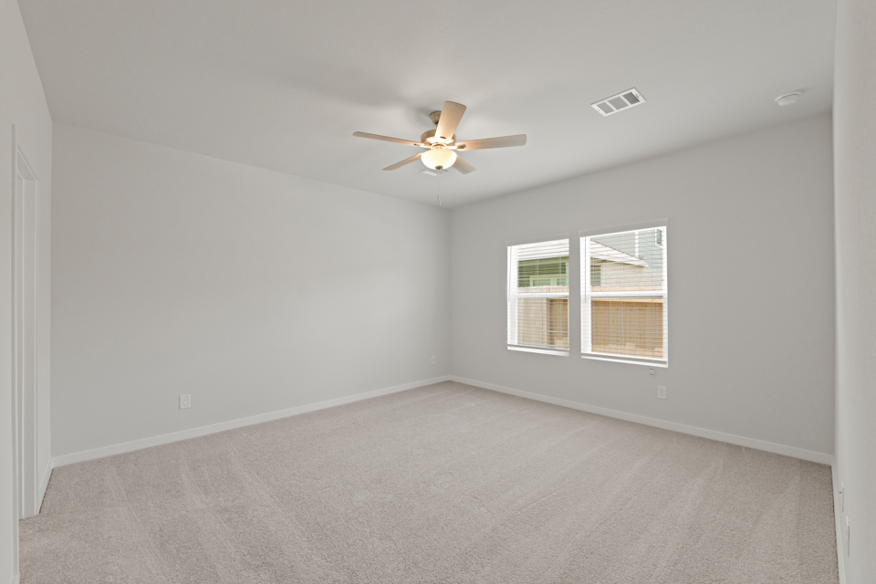 A room with a ceiling fan and a window.