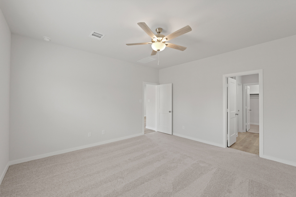 A room with a ceiling fan and a door.