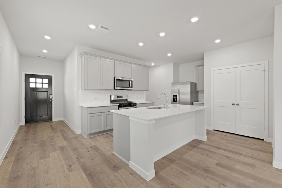 A kitchen with white cabinets.