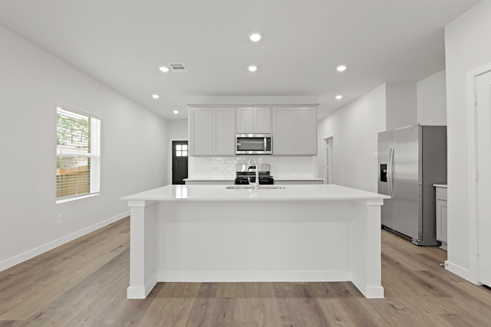 A kitchen with white cabinets.