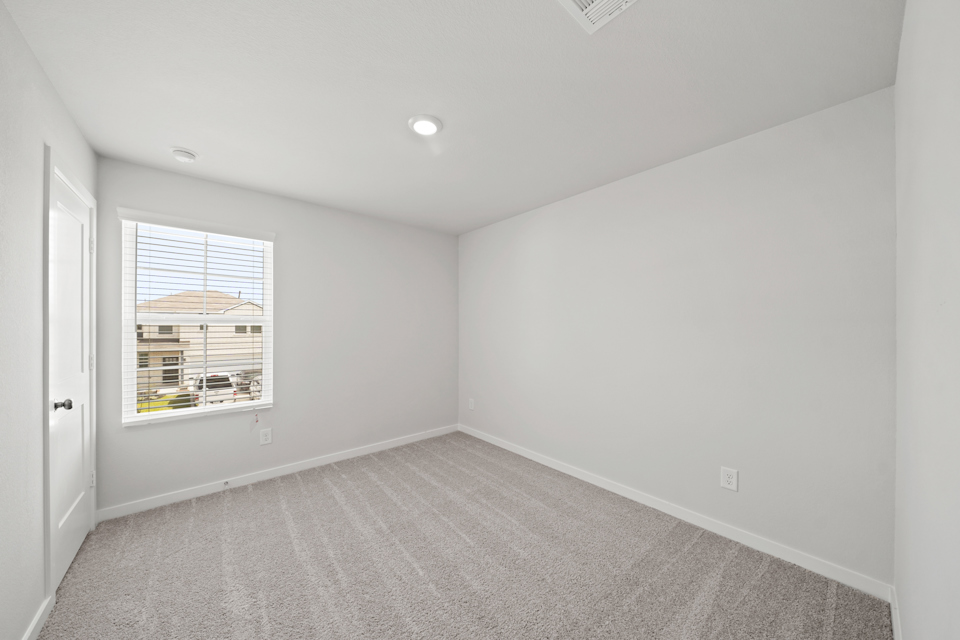 A room with a window and a carpet.