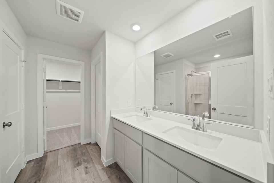 A bathroom with a tub sink and a mirror.