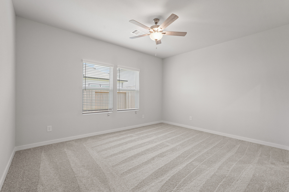 A room with a ceiling fan and a window.